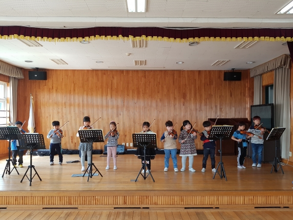 서천 송석초 방과후학교가 농사와 맞벌이 학부모들의 큰 근심거리를 해소해 나가고 있다. 바이올린 연주를 통해 친구들과의 화합을 배우고 있다.
