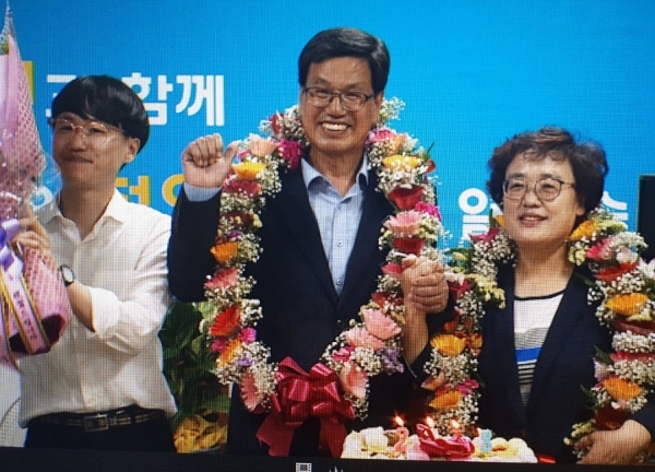 김돈곤 청양군수 후보가 13일 선거사무소에서 당선이 확정되자 부인과 함께 환호하고 있다.