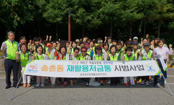 지난 15일 송촌동공동체활성화추진단이 ‘재활용저금통 시범사업’ 캠페인을 펼치고 기념촬영을 하고 있는 모습