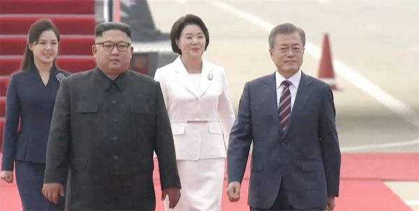 문재인 대통령이 18일 오전 10시 평양 순안국제공항에 도착한 뒤 영접나온 김정은 북한 국무위원장과 사열대로 향하고 있다. 영상캡처.