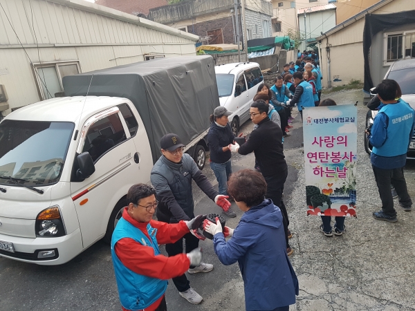 독거노인 가정에 연탄을 배달한 대전봉사체험교실 봉사자와 오류동 직원 모습