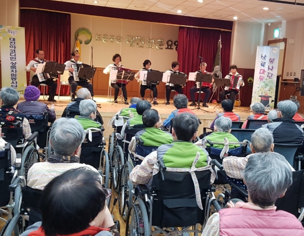 대전아코디언봉사단이 치매 및 각종 질환으로 심신이 지쳐있는 어르신들, 자원봉사자, 요양원 관계자들 100여명이 참석한 가운데 연주를 하고 있다.