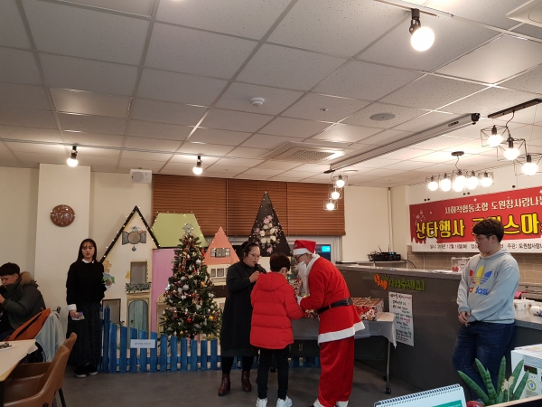 18일 저녁 도원참사랑나눔 권경미 이사장과 산타가 어린이에게 선물을 전달하는 모습