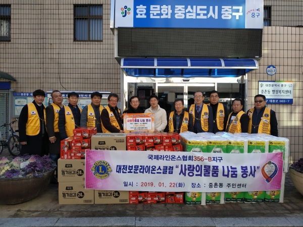22일 중촌동에 생필품을 전달한 대전보문라이온스클럽 박근용회장(왼쪽에서 5번째)와 전달받은 김기돈 동장(왼쪽에서 7번째)
