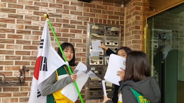 28일 우편함에 태극기 달기 홍보물을 넣은 유천2동 자원봉사자 학생들 모습