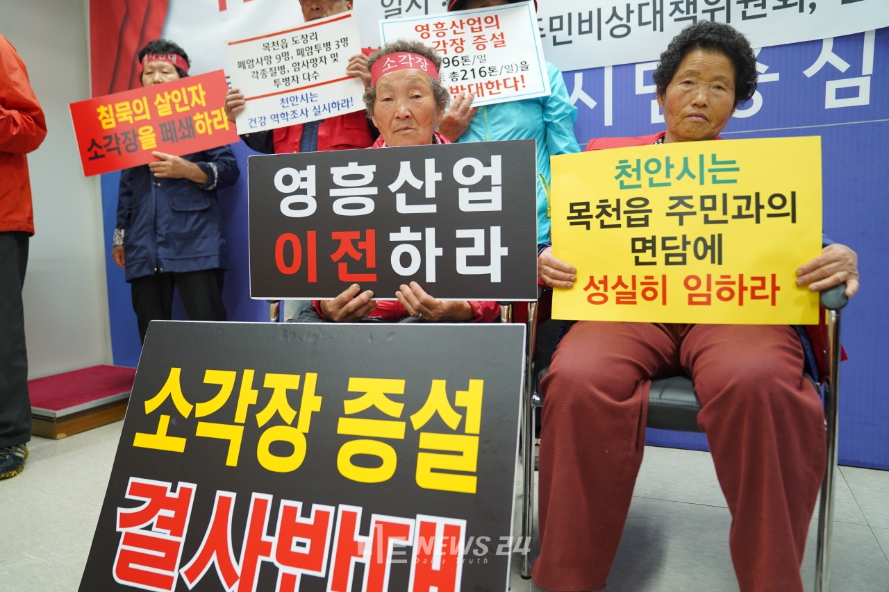 천안 목천읍 주민들이 24일 시청 브리핑실 기자회견에 참석, 소각장 증설 반대 문구가 적힌 피켓을 들고 있다.