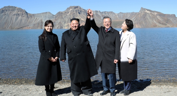 지난해 9월 평양 정상회담에서 문재인 대통령이 김정은 북한 국무위원장과 백두산 천지에 올라 손을 들어보이고 있다.