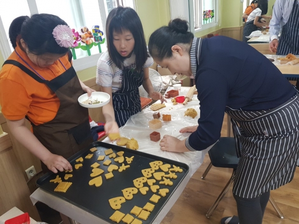 지난 18일 은샘공동체 2층에서 신성동 지역사회보장협의체 위원들이 사업 대상자들과 함께 쿠키만들기 프로그램에 참여하고 있다.