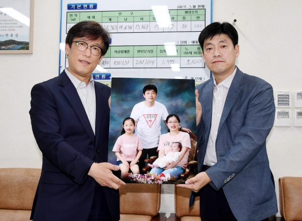 출산축하 가족 사진을 전달하는 이준석 동장(왼쪽), 사진 주인공인 김학신 씨(오른쪽)