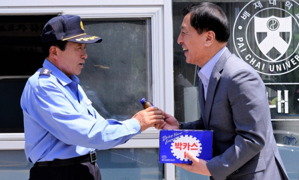 김선재(오른쪽) 배재대학교 총장이 17일 대학 발전기금을 쾌척한 경비원 조동주 씨에게 음료를 전달하고 있다. 배재대 제공