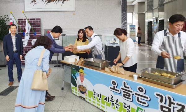15일 구본영 천안시장(가운데)이 시청 로비에서 직원들에게 찐 감자를 나눠주고 있다.