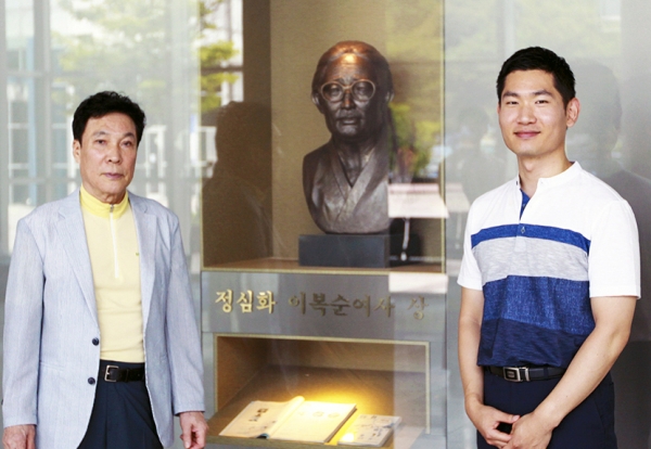 유가족 임채훈 씨(왼쪽)와 박준표 동문(오른쪽)이 정심화국제문화회관 내에 마련된 정심화 이복순 여사 동상 앞에서 기념 사진을 찍었다.