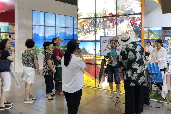 대한민국 국제 관광박람회 참가한 서산시 부스, 부스 뒤 배경에 해미읍성 축제 장면이 연출되고 있다