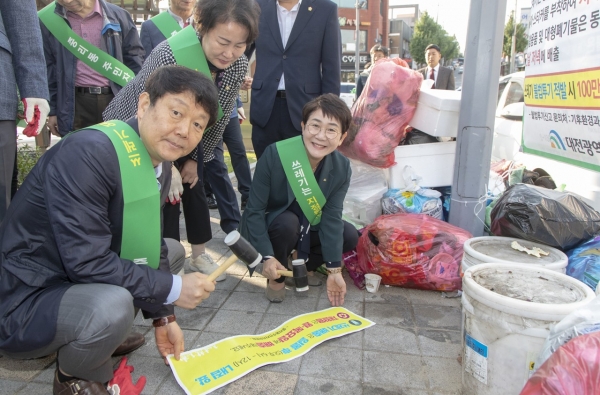 쓰레기 배출시간 안내 및 불법 투기 금지 스티커를 붙이고 있는 박정현 대덕구청장