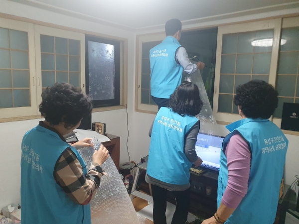 16일 온천1동 지역사회보장협의체 위원들이 관내 독거어르신 가정을 방문해 방풍필름을 설치하고 있다.