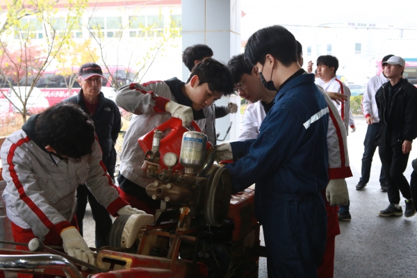 신성대학교 사회봉사단 학생들이 농기계 수리 봉사를 하는 장면