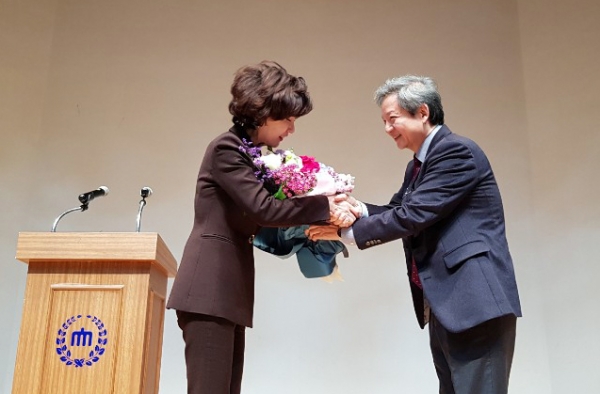 이진숙 교수(왼쪽)에게 축하 꽃다발을 전달하는 김정윤 충남대 총장추천위원장(오른쪽).