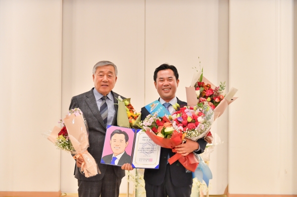 박정현 부여군수(오른쪽)가 풀뿌리 자치대상 행정종합대상을 수상하고 기념촬영을 하고 있다.