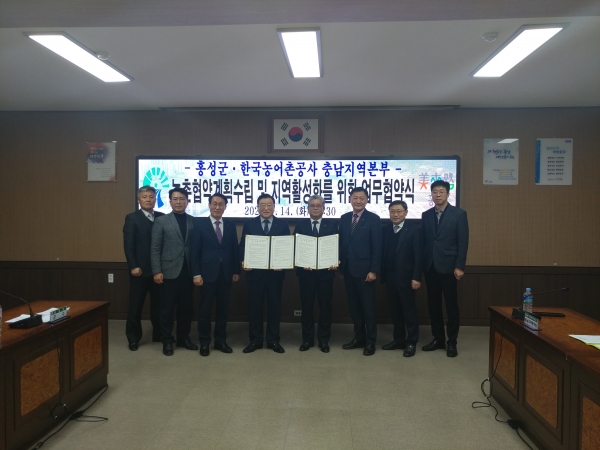 안중식 농어촌공사충남지역본부장(사진왼쪽 협약서)과 김석환 홍성군수(사진 오른쪽 협약서)가 직원들과 함께 업무협약 기념사진을 찍고 있다.