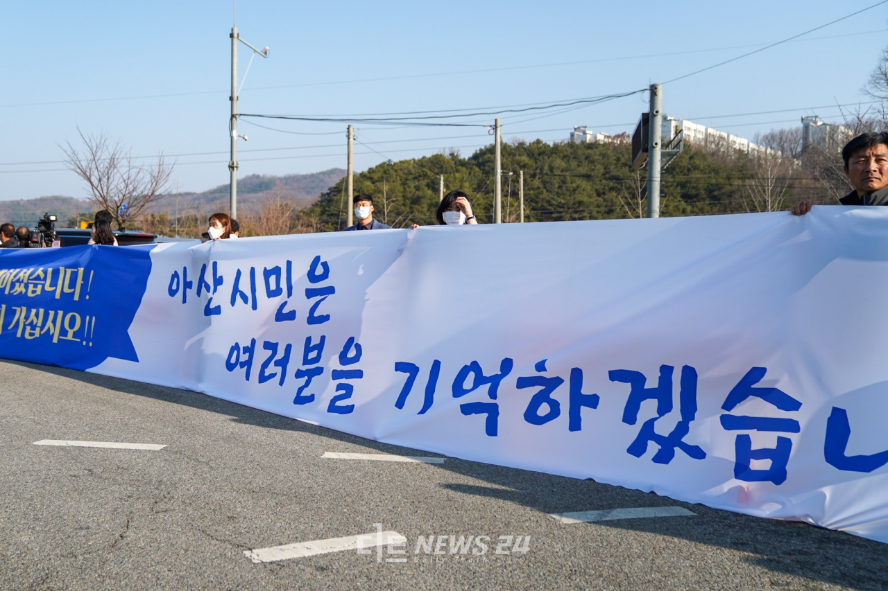 15일 아산지역 주민들이 대형 현수막을 들고 퇴소 하는 우한교민을 환송했다.