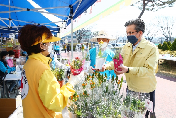 25일 유성구청 본관 앞에서 정용래 유성구청장이 화훼농가 살리기 캠페인에 참여해 화분을 구매하고 있다.