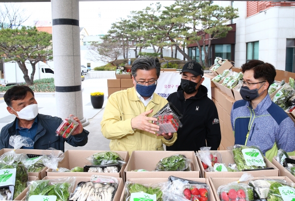 26일 구청 현관 앞에서 정용래 유성구청장이 일만 원 상당의 지역농산물꾸러미를 구매하고 있다.