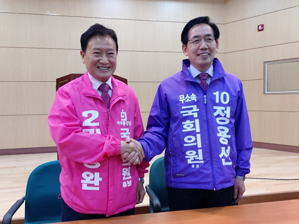 김동완, 정용선 국회의원 후보가 단일화서명을 한 뒤 악수를 하고 있다.