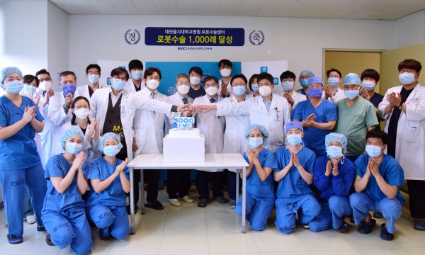 대전을지대병원이 지역 최초 로봇수술 1천례 달성했다. 6일 김하용 원장과 로봇수술센터 의료진 및 관계자들이 로봇수술 1천례 달성을 자축하고 있다.