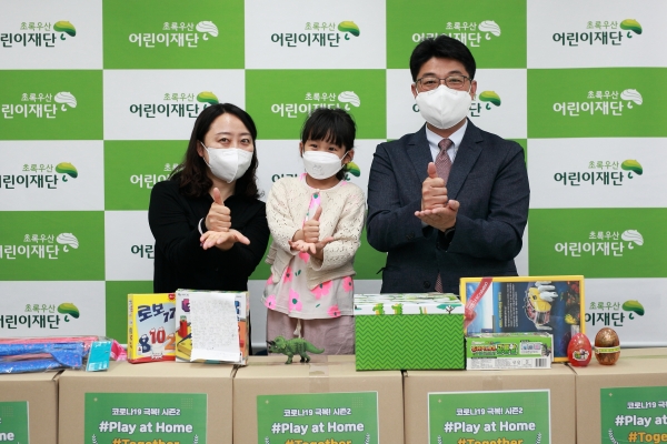 세종시민 송OO씨와 이OO아동(왼쪽)이 초록우산어린이재단 세종아동옹호센터 최승인소장에게 'play at home' 놀이키트를 전달하고 있다.