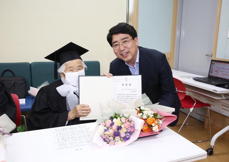 서산  ‘성인문해교육 배움교실’ 졸업식에서 김세영 할머니가 졸업장을 받고 즐거워하고 있다. 오른쪽은 맹정호 서산시장.