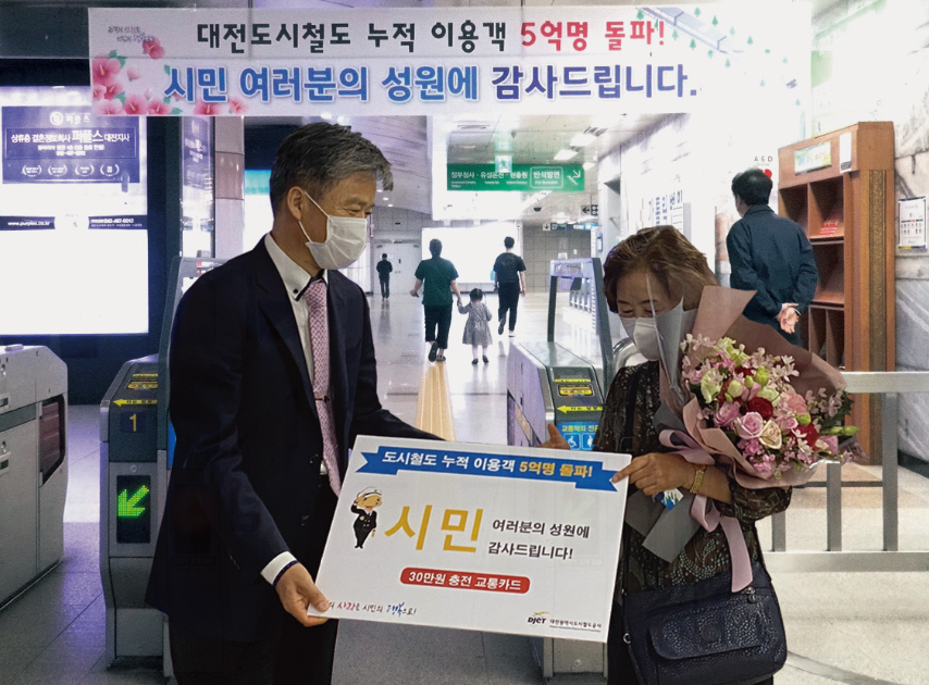 김경철 대전도시철도공사 사장(왼쪽)이 대전도시철도 5억 번째 이용 승객에게 기념 교통카드를 선물하고 있다.