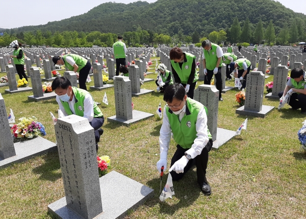 국민연금공단 임직원들이 4일 국립대전현충원을 방문 묘역 정화 봉사를 실시하고 있다.