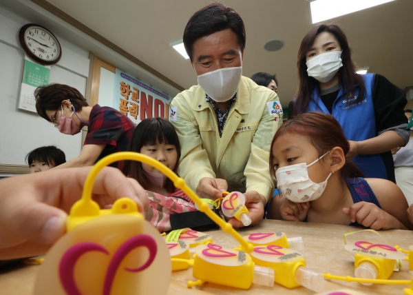 황인호 동구청장(가운데)이 지역아동센터 이용 아동들에게 손소독제 사용 방법을 설명 중이다.