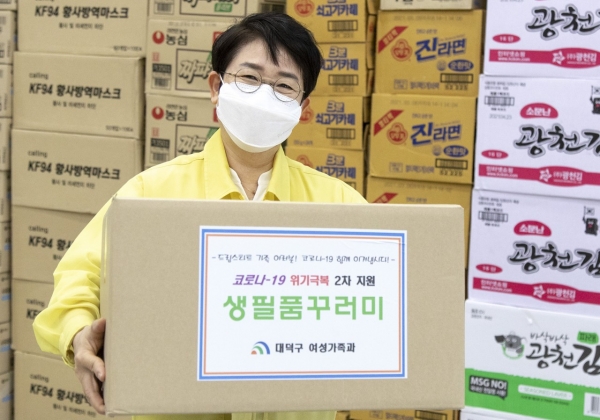 박정현 대덕구청장이 취약계층 아동들에게 배송될 생필품꾸러미를 포장해 들어 보이고 있다.