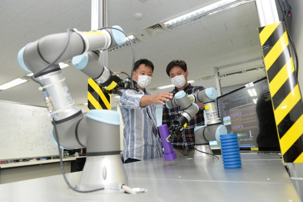 ETRI 연구진이 개발한 스마트팩토리용 로봇 자율지능 기술을 점검하는 모습. 왼쪽부터 한효녕 선임연구원, 김현석 선임연구원.