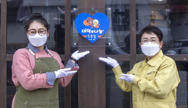 박정현 대덕구청장이 신탄진동 ‘커피를福堂’에서 대덕e나눔 5호점 지정 현판을 부착하고 있다.