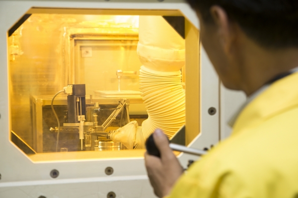 연구원이 로봇팔로 방사성동위원소 생산작업을 하고 있다.
