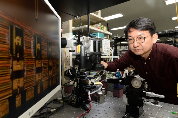 ETRI 한영탁 책임연구원이 400G 광학송수신엔진에 사용된 반도체 광원 칩 살펴보고 있는 모습.