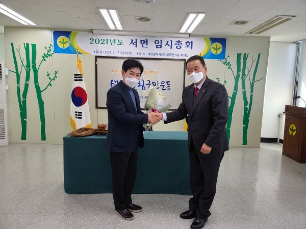 양용모 대전시새마을회 신임 회장에게 축하 꽃다발을 전달하고 있다.