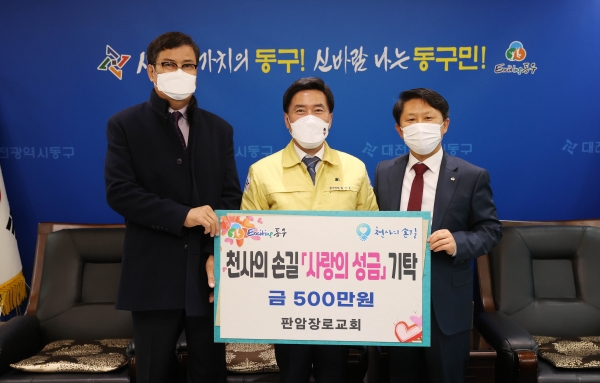 황인호 동구청장과 홍성현 담임목사가 500만 원을 후원하고 있다.