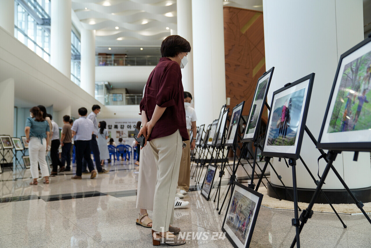 충남도청 직원들이 11일 도청 1층 로비에서 열린 '압록강 아이들' 사진전을 관람하고 있다. 황재돈 기자.