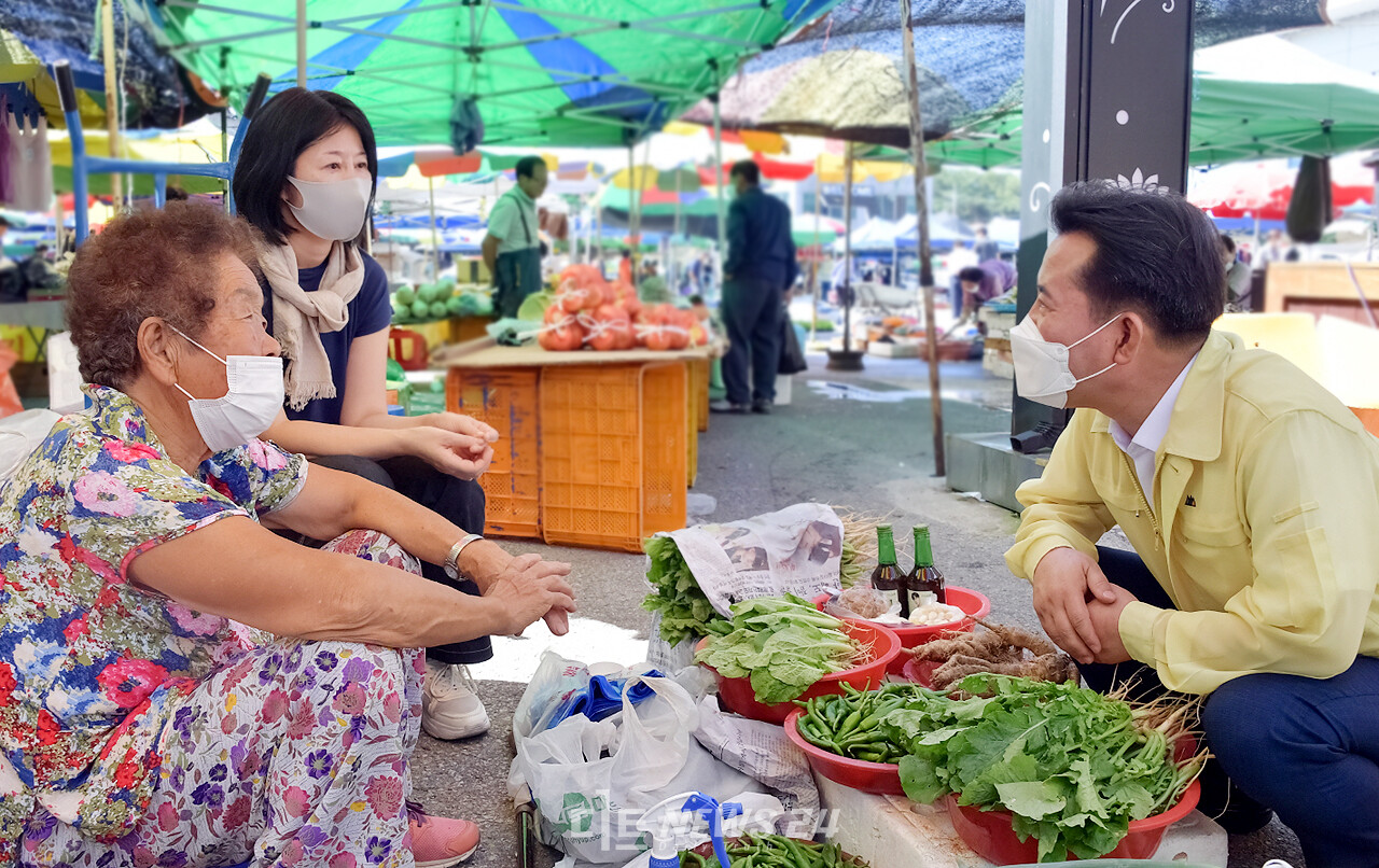 박정현 부여군수가 자신과 가족이 받은 재난지원금을 어려운 이웃을 위해 사용하도록 기탁한 사실이 뒤늦게 알려졌다. 16일 오후 전통시장 상인을 찾아 대화를 나누는 박 군수(오른쪽). 부여군청 제공.