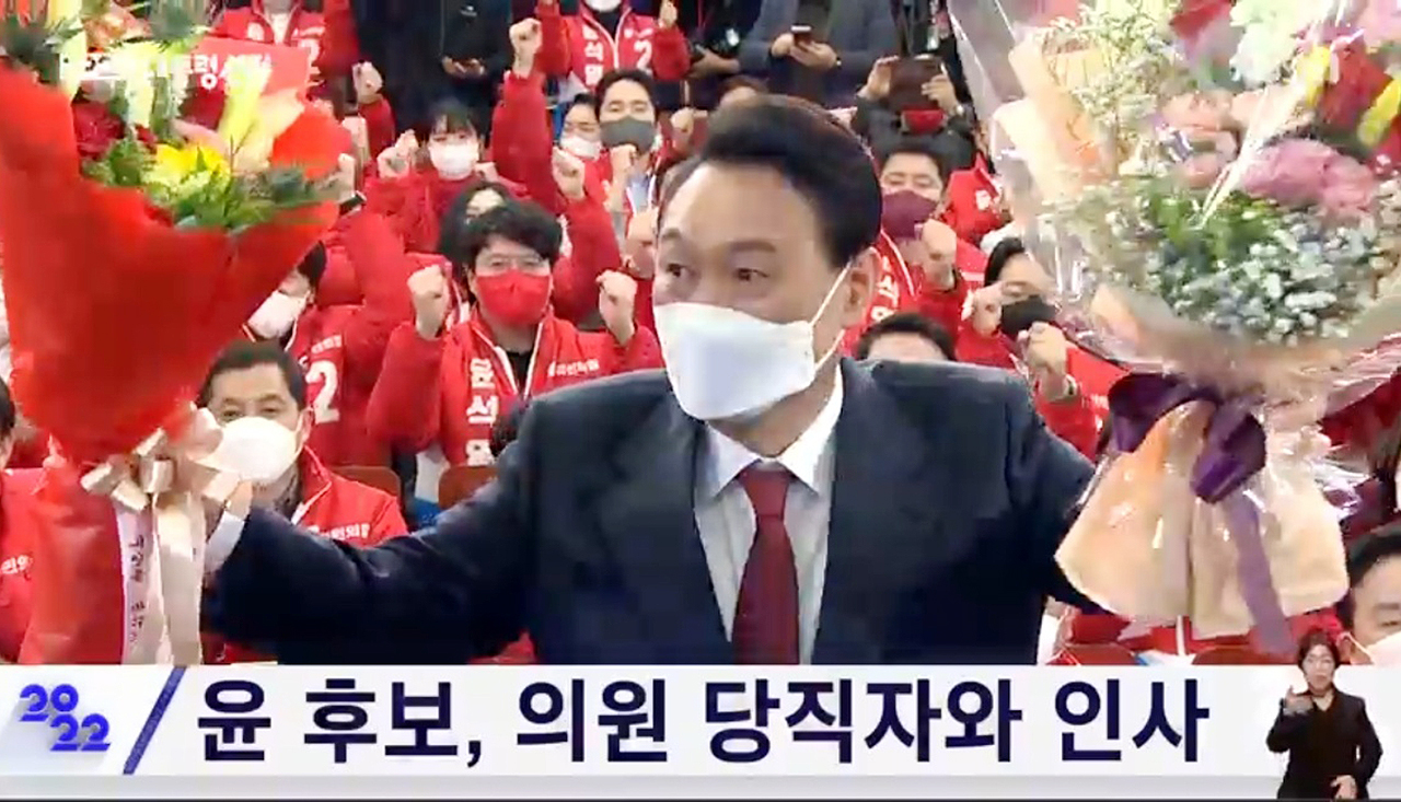 윤석열 대통령 당선인이 국회 상황실에 도착해 당직자로부터 당선 축하 꽃다발을 받고 인사하고 있다. KBS중계화면 갈무리.
