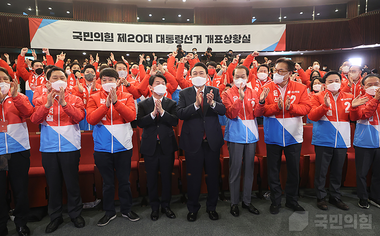 윤석열 대통령 당선인이 10일 새벽 국회 도서관에 마련된 국민의힘 선거 개표상황실에 도착해 당 지도부와 당직자, 안철수 국민의당 대표 등으로부터 축하를 받고 있다. 국민의힘 홈페이지.