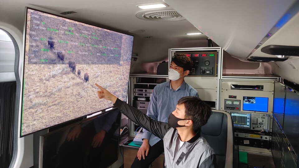 ETRI 연구진이 UHD 측정 차량 내부에서 8K-UHD 전송 기술을 시연하는 모습.