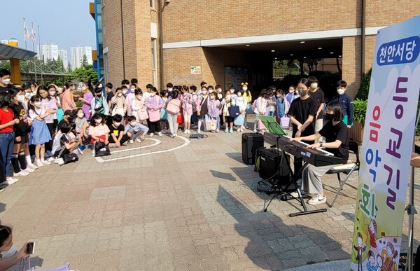 천안서당초가 지난 4일부터 격주로 등굣길 움악회를 개최하는 가운데 18일 김수아(6년)양이 피아노곡 크로아티안 랩소다를 연주하고 있다.