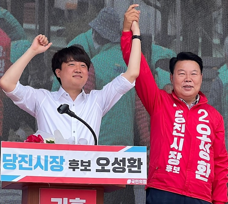 이준석 국민의힘 대표(좌)가 25일 당진어시장을 찾아 오성환 당진시장 후보의 손을 들어주고 있다. 오성환 캠프제공.