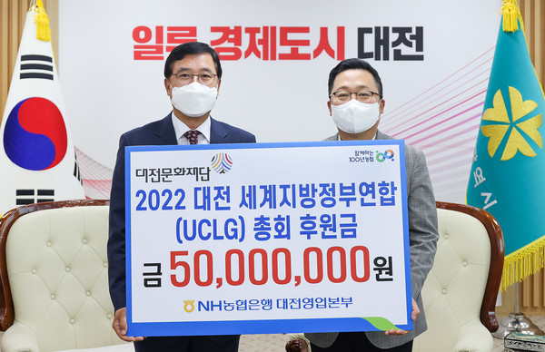 NH농협은행 대전영업본부 김동수 본부장(좌측)과 이장우 대전시장(우측)이 UCLG 후원금 전달식을 갖고 기념촬영을 하고 있다.