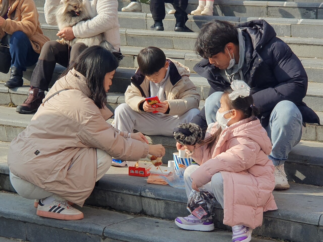축제장을 찾은 한 가족이 계단에 옹기종기 모여 간식을 먹고 있다. 김다소미 기자.