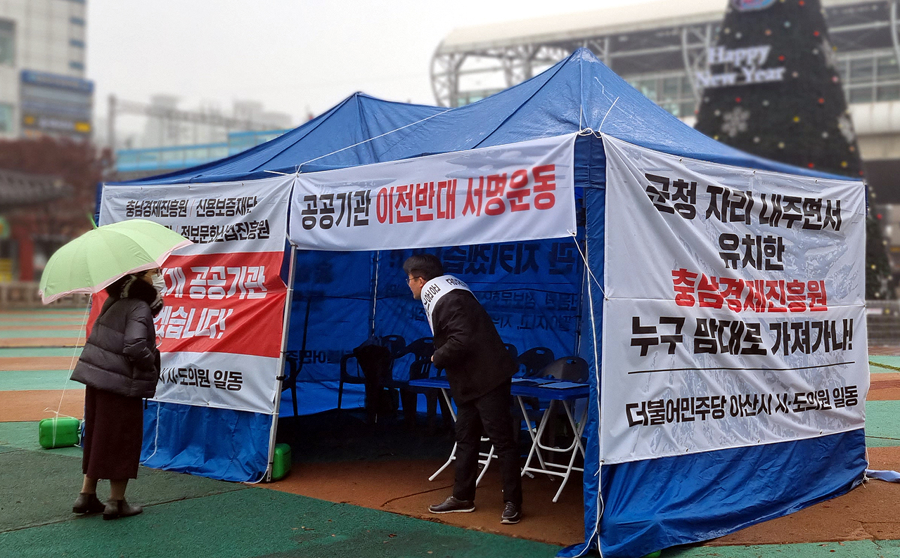 온양온천역 광장 한켠에서 천막을 지키고 있는 안장헌 의원(오른쪽)이 지나가는 시민과 대화 중이다. 천막농성은 일단 명절 전까지 진행할 방침이다. 안성원 기자.